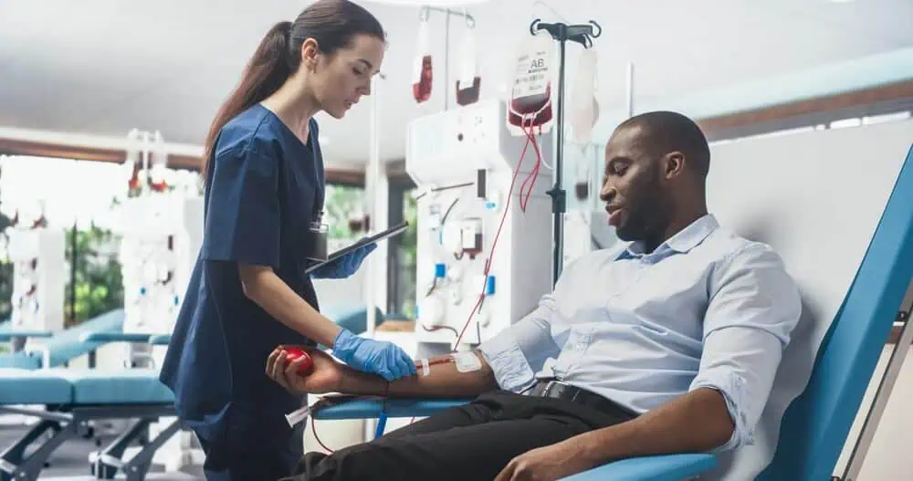 A female doctor drawing blood from a male patient