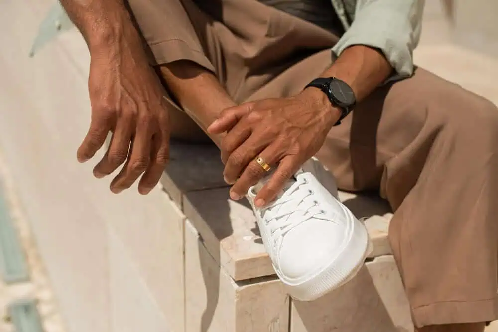 Man wearing health ring in athletic clothes sitting outside.